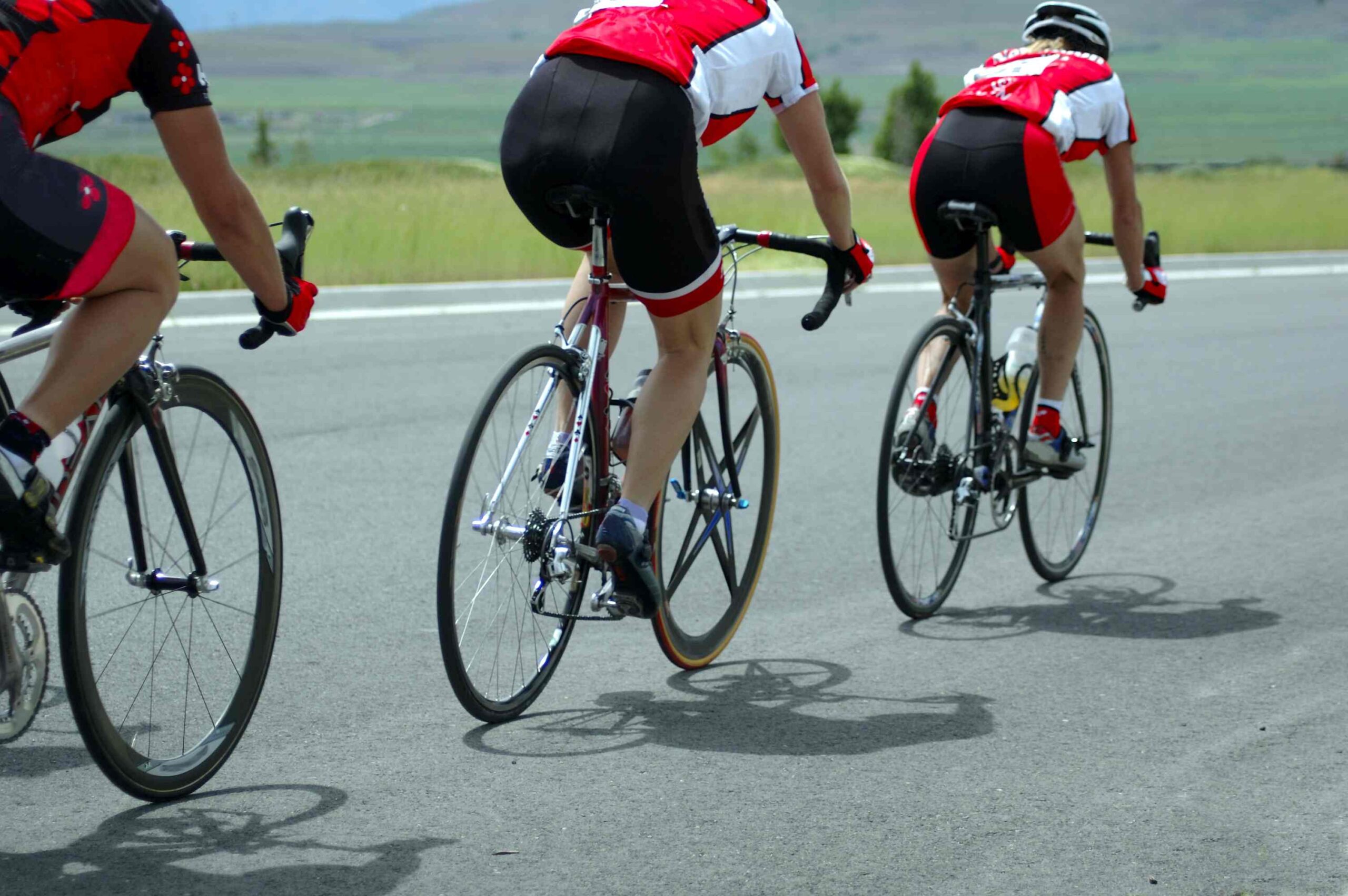 Three bike riders race toward the finish line