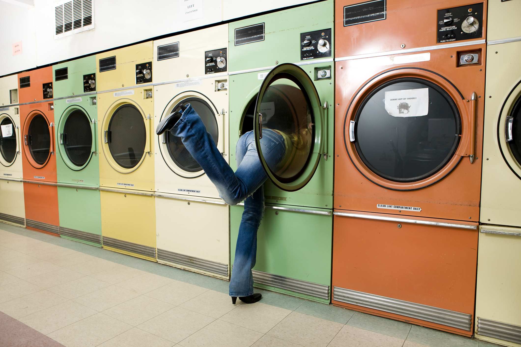 Girl Leaning into Laundromat Washer to Get Clothes