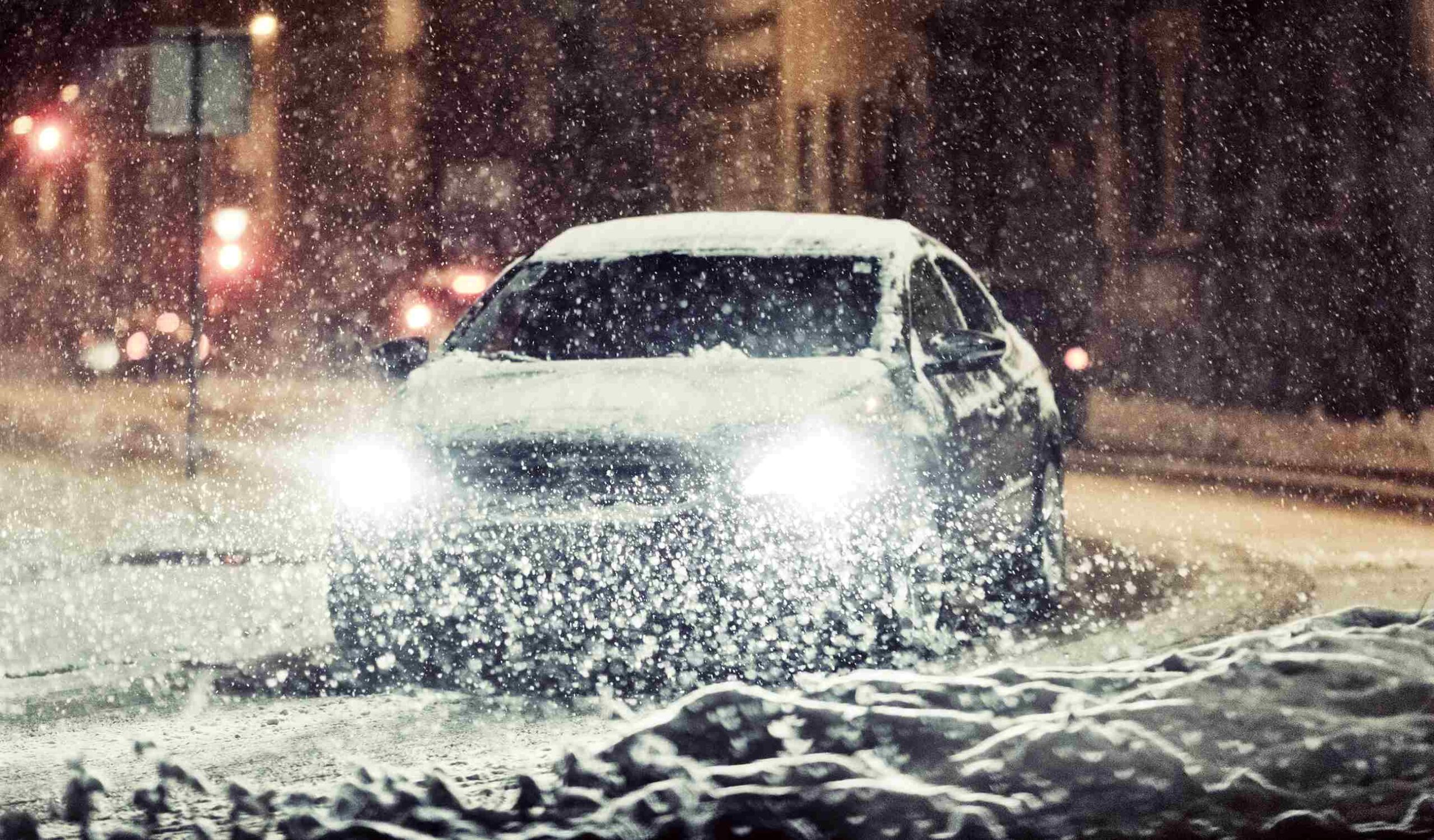 Car driving through a severe snow storm at night