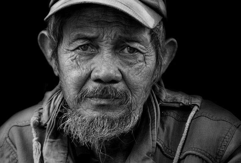 Old man with a weathered face wearing a baseball cap