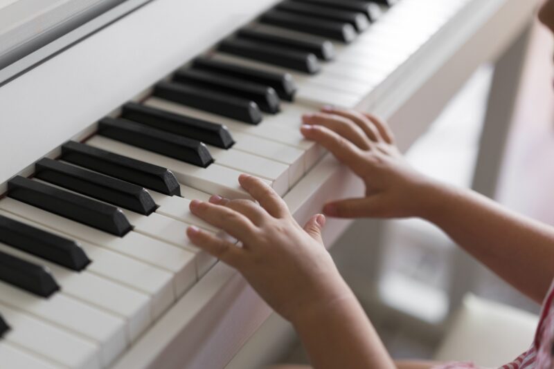 Little girl's small hands playing a piano