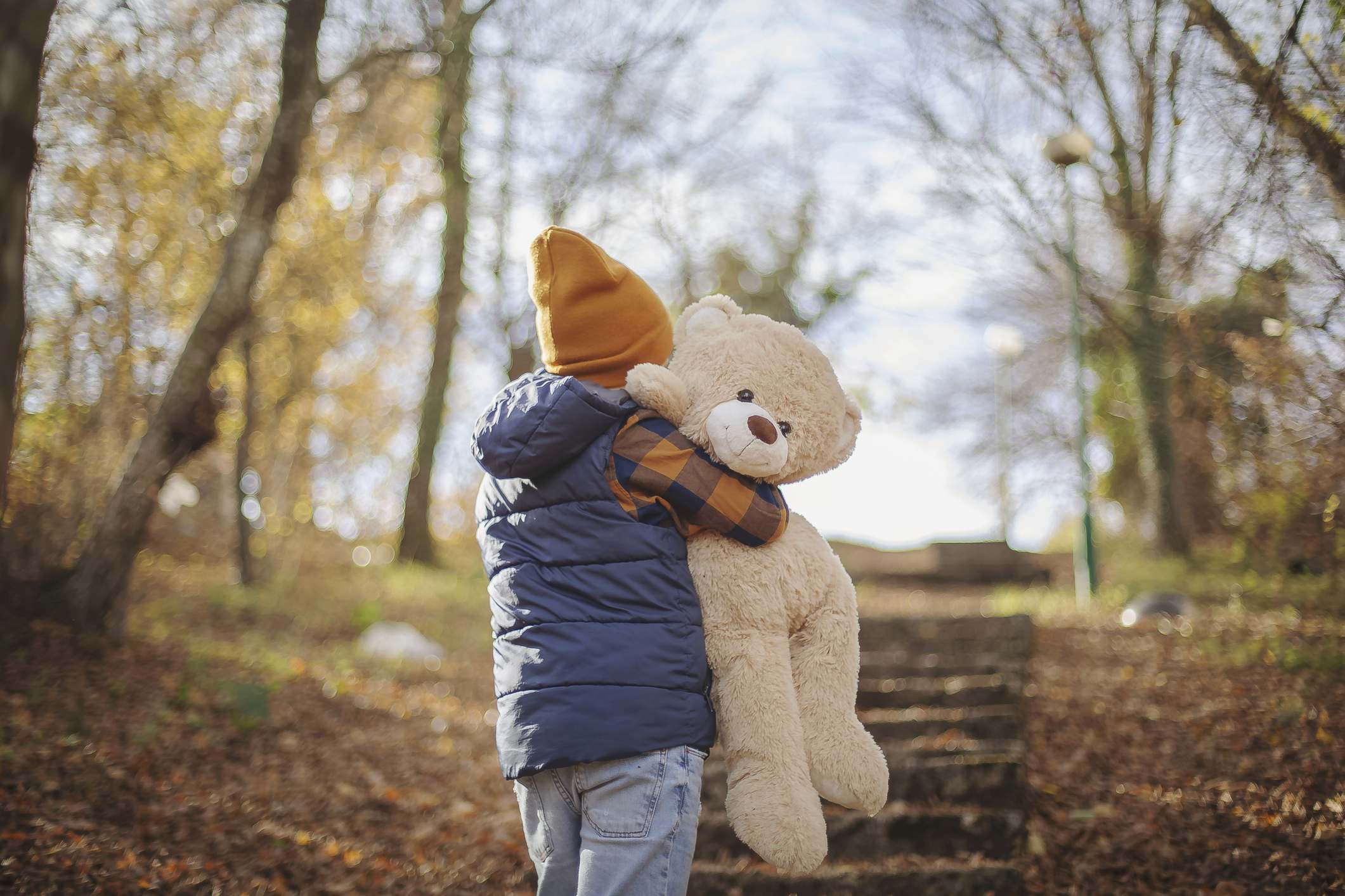 Boy enjoying day in the nature with his teddy bear
