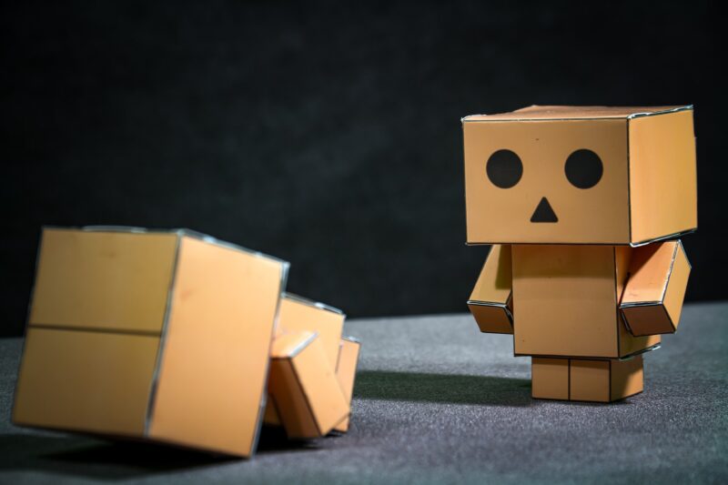 Funny robot made of cardboard boxes on dark background. 3d illustration