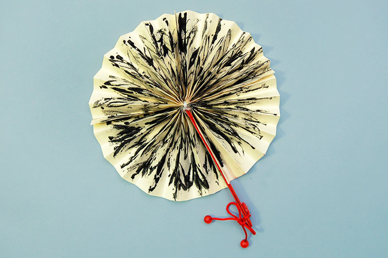 Asian Folding Fan Simple circular Asian folded fan in cream and black, with a red handle