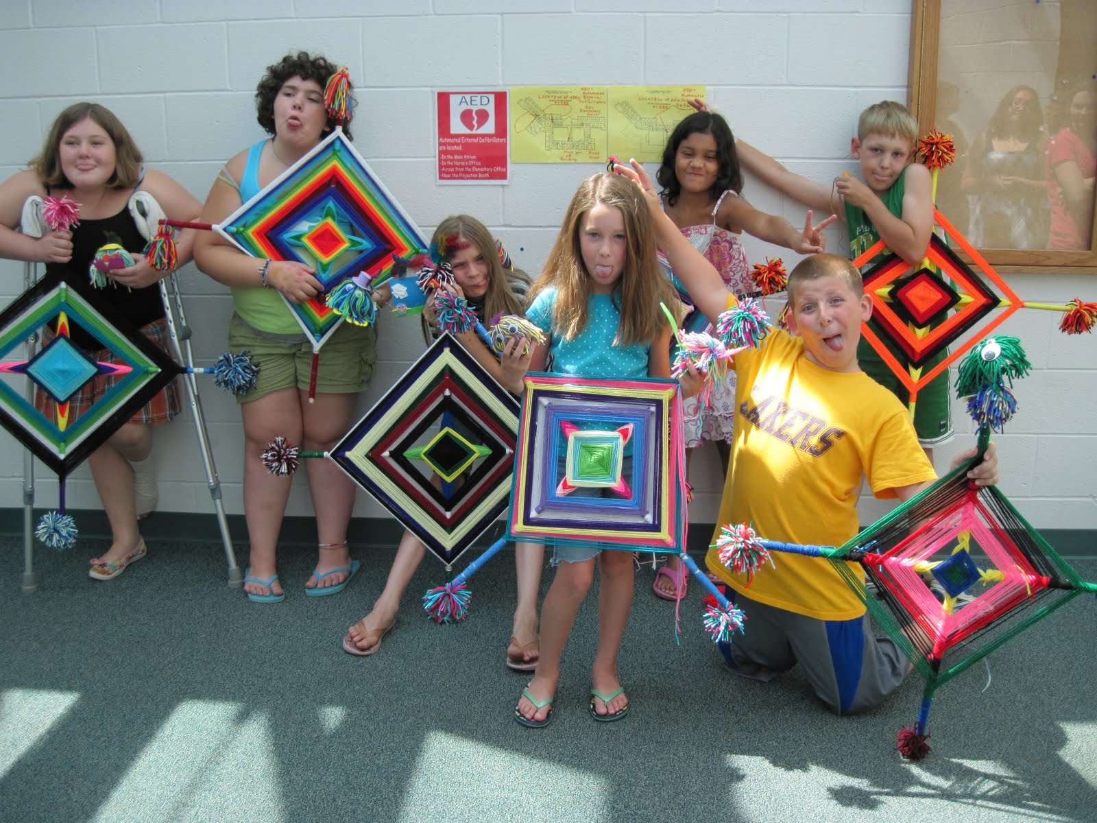 Oversized Gods-Eyes Third graders holding giant gods-eye weavings
