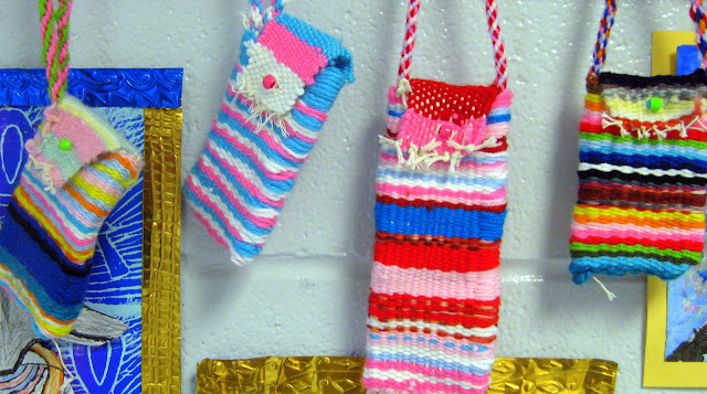 Three colorful oblong pouches woven from yarn by fourth grade art students